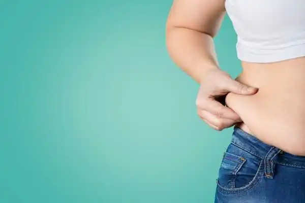 Image of woman pinching her love handles to show weight gain Liverpool